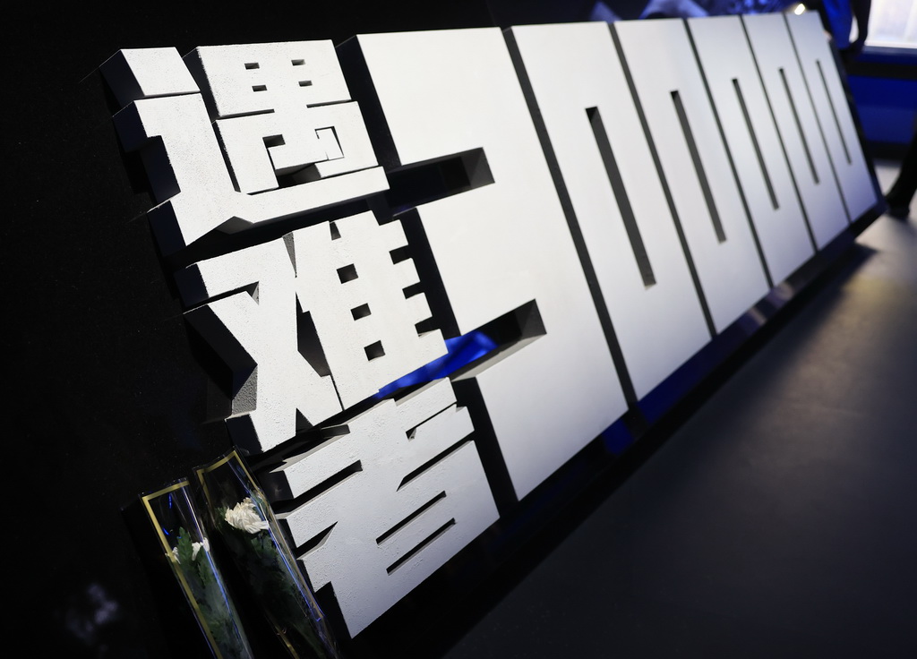 2025年7月8日,参观者在位于北京的中国人民抗日战争纪念馆参观《为了民族解放与世界和平》主题展览时,留下两朵白菊纪念南京大屠杀遇难者。新华社记者 张晨霖 摄